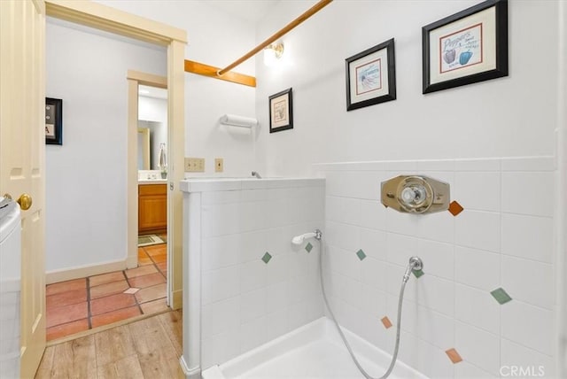 bathroom featuring a tile shower, vanity, and hardwood / wood-style flooring