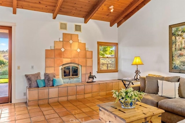 living room with beamed ceiling, wooden ceiling, light tile patterned floors, and a tiled fireplace