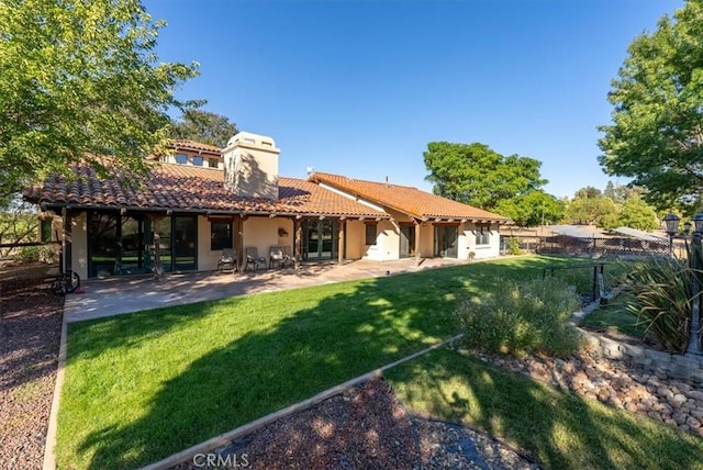 back of house featuring a lawn and a patio