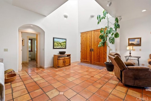 tiled living room featuring a high ceiling