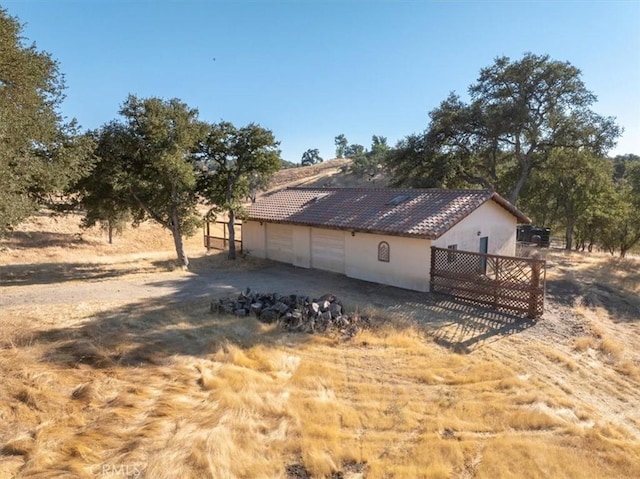 view of side of home featuring a rural view and a garage