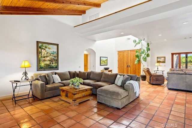 living room with beam ceiling, light tile patterned floors, and wood ceiling