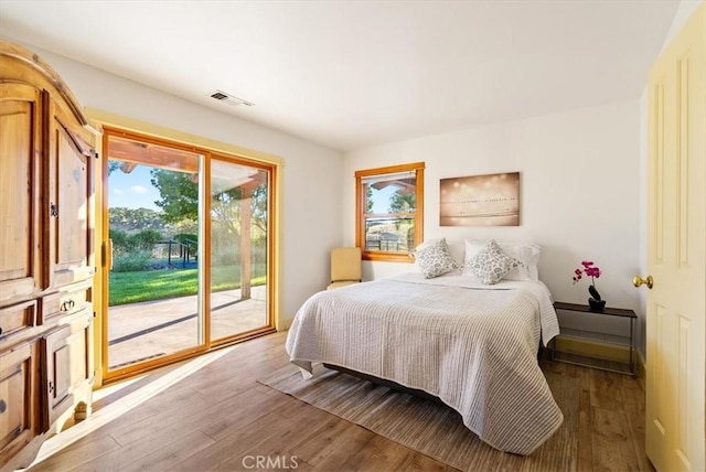 bedroom with wood-type flooring and access to outside