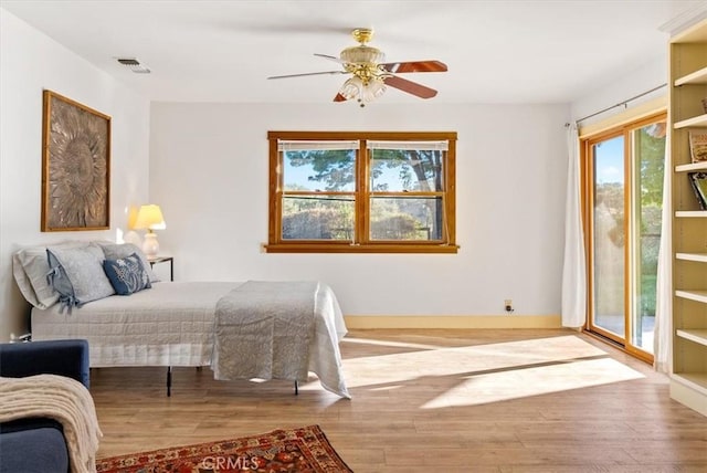 bedroom with access to exterior, light hardwood / wood-style floors, and ceiling fan