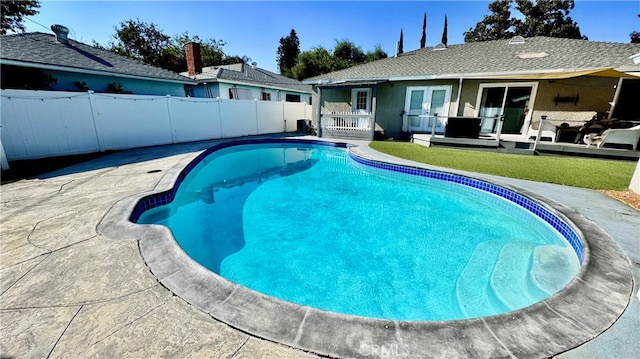 view of swimming pool with a patio and a lawn