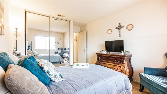 bedroom featuring carpet floors, a closet, and visible vents