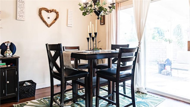 dining space featuring dark wood-style floors and baseboards