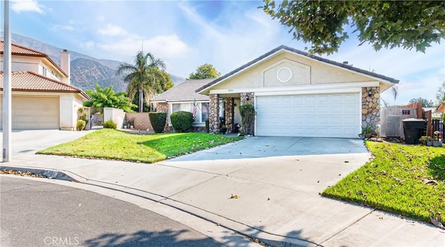 ranch-style home with concrete driveway, an attached garage, a front yard, a mountain view, and fence