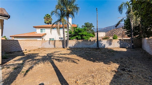 view of yard featuring a fenced backyard and a mountain view