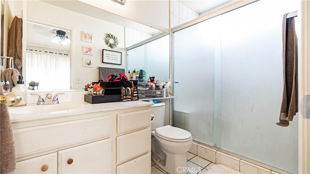 bathroom featuring a stall shower, tile patterned flooring, vanity, and toilet