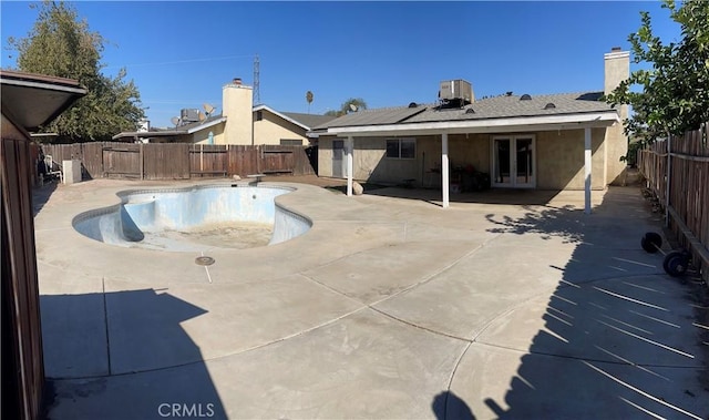 view of pool featuring a patio area, french doors, and central AC unit