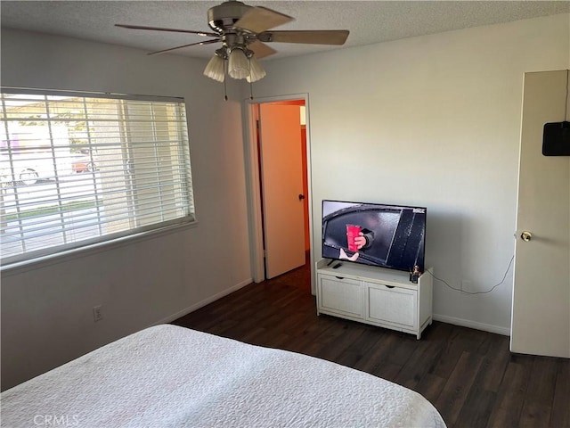 bedroom featuring ceiling fan, dark hardwood / wood-style flooring, and a textured ceiling