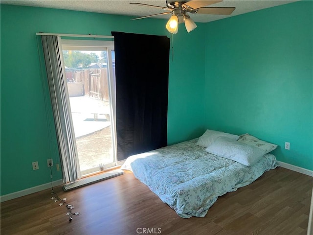 bedroom featuring hardwood / wood-style floors, a textured ceiling, and ceiling fan