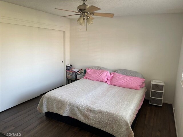 bedroom featuring ceiling fan, dark wood-type flooring, and a textured ceiling