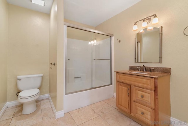 full bathroom featuring combined bath / shower with glass door, vanity, toilet, and tile patterned flooring