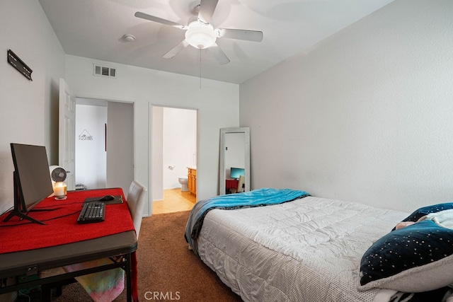 carpeted bedroom with ensuite bath and ceiling fan