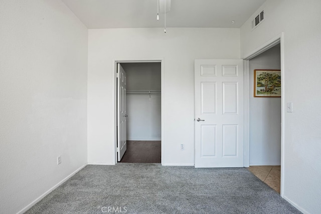 unfurnished bedroom featuring carpet, ceiling fan, and a closet