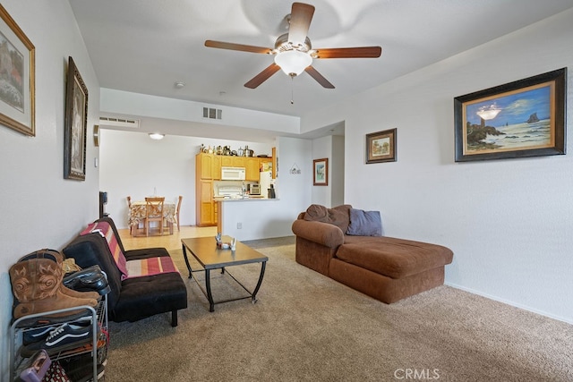 living room featuring ceiling fan and light colored carpet