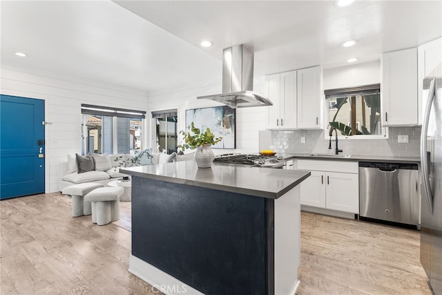 kitchen with stainless steel dishwasher, white cabinetry, sink, and island range hood