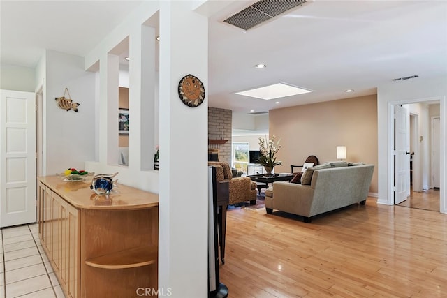 interior space with light hardwood / wood-style floors and a skylight