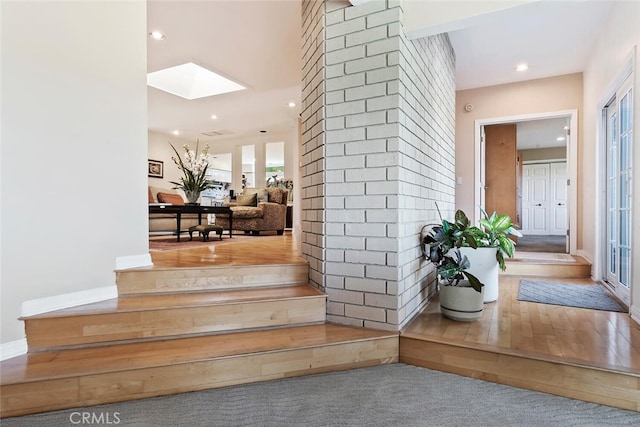 staircase featuring a skylight and carpet