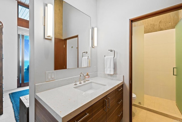 bathroom with walk in shower, vanity, tile patterned flooring, and toilet