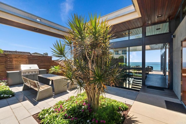 view of patio / terrace with area for grilling and a water view