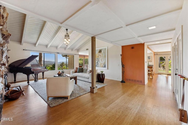 living room featuring wood-type flooring and vaulted ceiling with beams