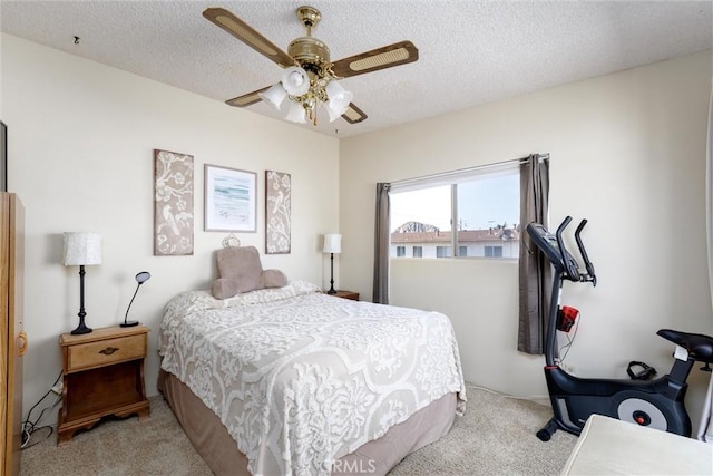 carpeted bedroom with ceiling fan and a textured ceiling