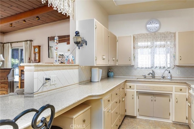 kitchen featuring beamed ceiling, sink, backsplash, wood ceiling, and cream cabinetry