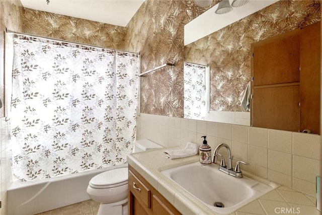 full bathroom with vanity, toilet, shower / tub combo, and tile walls