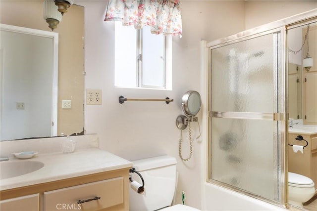 full bathroom featuring toilet, vanity, and shower / bath combination with glass door