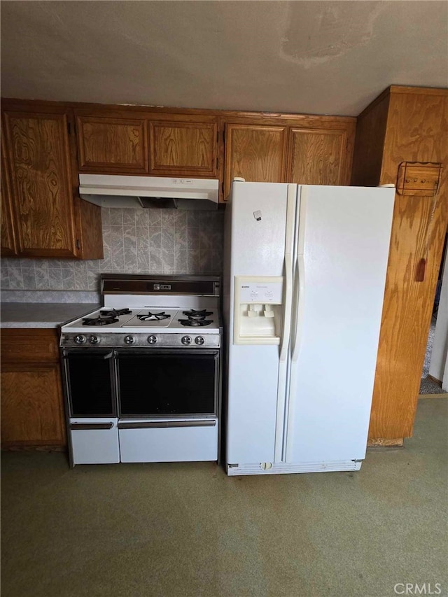 kitchen featuring decorative backsplash, white appliances, and carpet floors