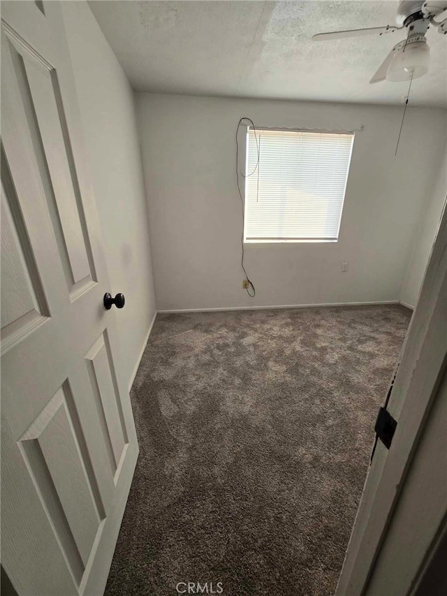 carpeted spare room with ceiling fan and a textured ceiling