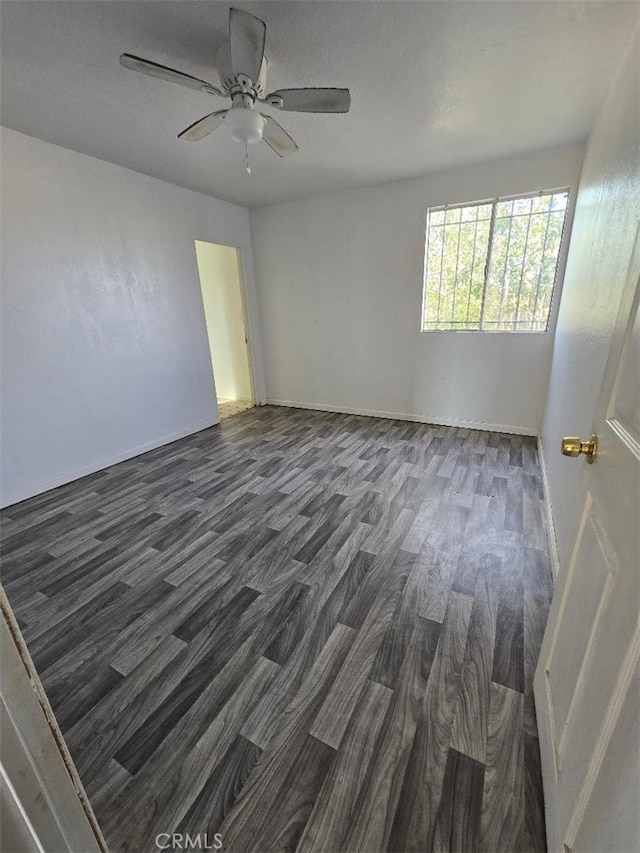 spare room featuring ceiling fan and dark hardwood / wood-style flooring