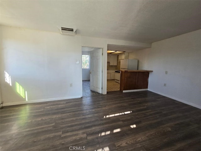 unfurnished living room with dark wood-type flooring