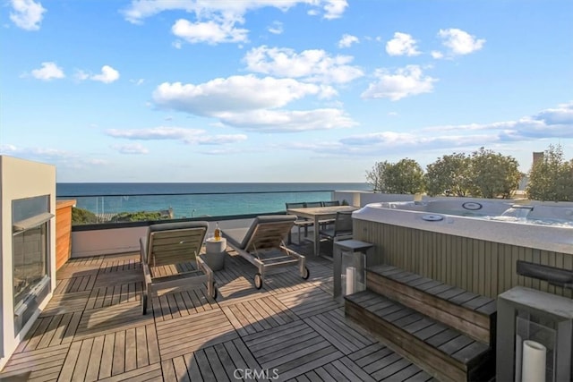 wooden deck featuring a water view and a hot tub