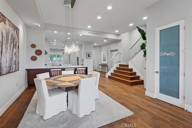 dining space with wood-type flooring and a chandelier