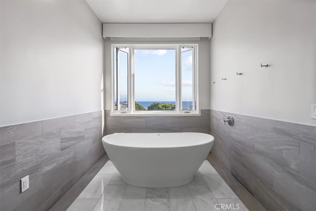 bathroom featuring tile walls and a bath