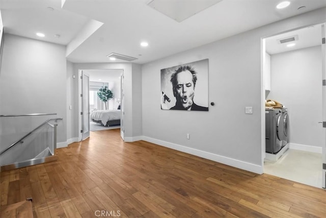 interior space with washing machine and clothes dryer and hardwood / wood-style flooring