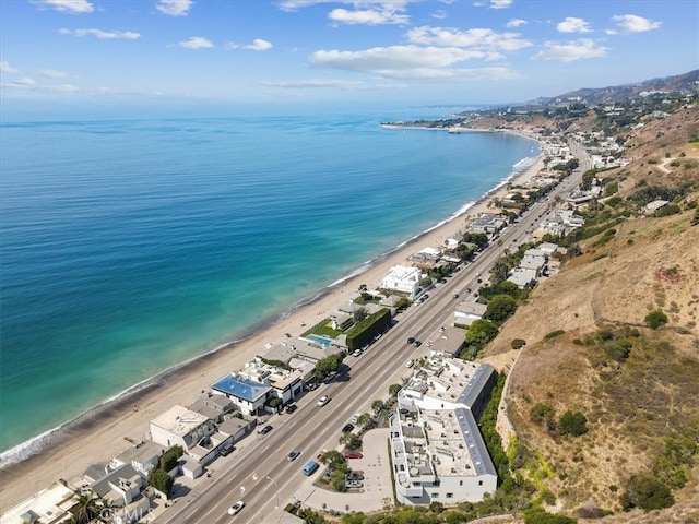 birds eye view of property featuring a water view and a beach view