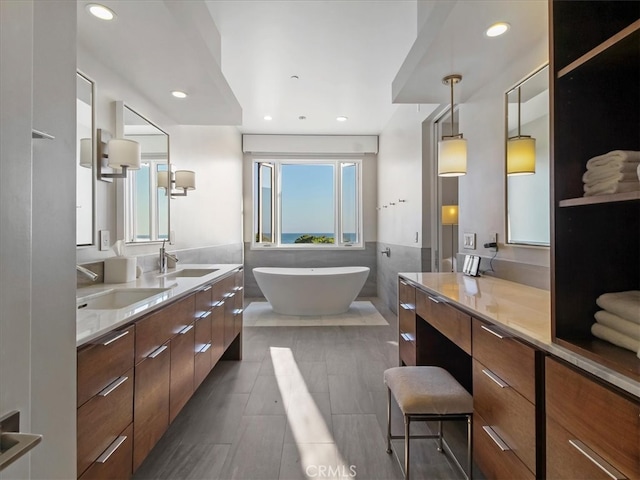 bathroom with vanity and a washtub