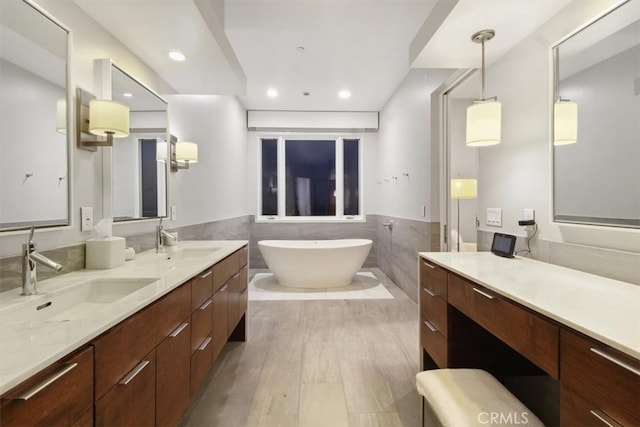 bathroom featuring vanity, tile walls, a bath, and hardwood / wood-style flooring