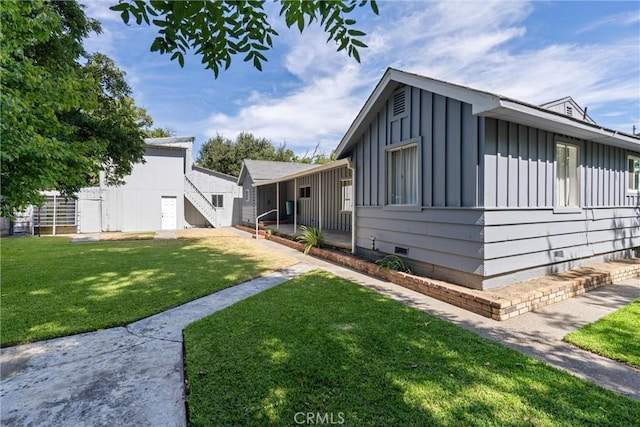 view of front of property featuring board and batten siding, crawl space, and a front yard