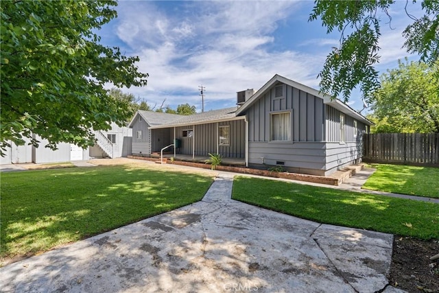 view of front facade featuring a front lawn, crawl space, fence, and board and batten siding