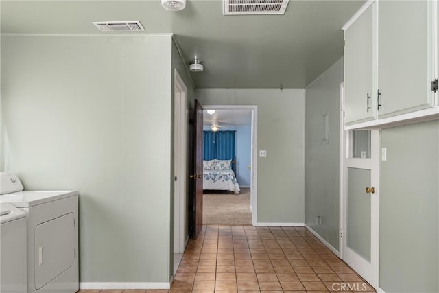 washroom featuring cabinets, light tile patterned floors, and washing machine and dryer