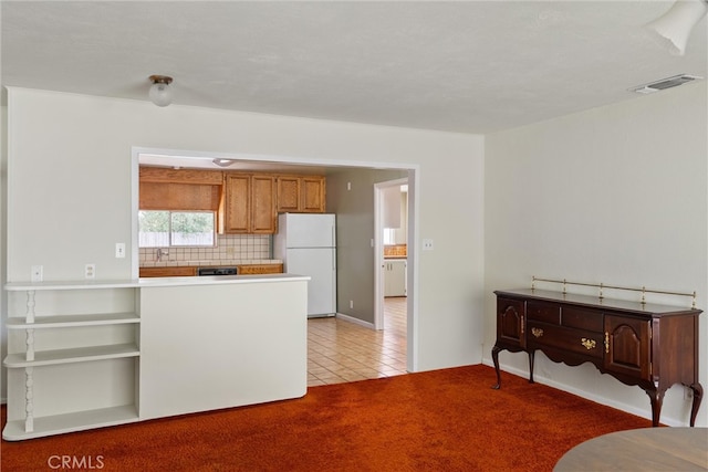 kitchen with light carpet, white refrigerator, and tasteful backsplash