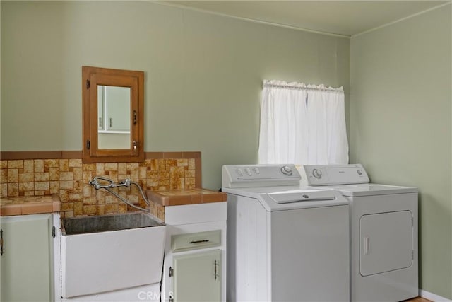 laundry area with cabinet space, a sink, and washer and clothes dryer