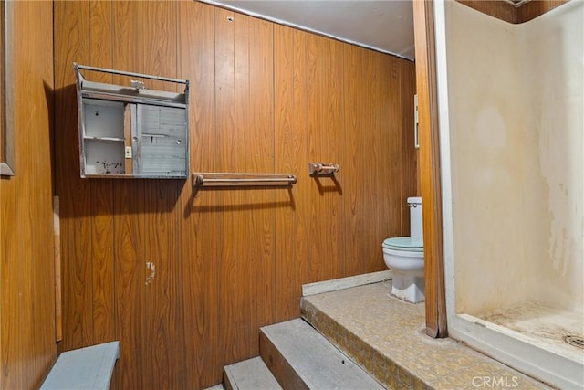 bathroom featuring wooden walls and toilet