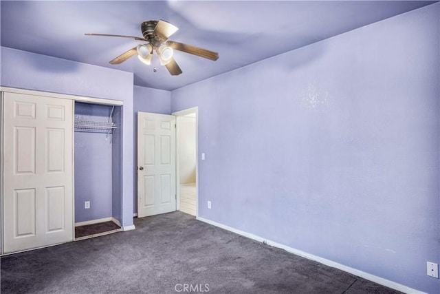 unfurnished bedroom with ceiling fan, dark carpet, and a closet